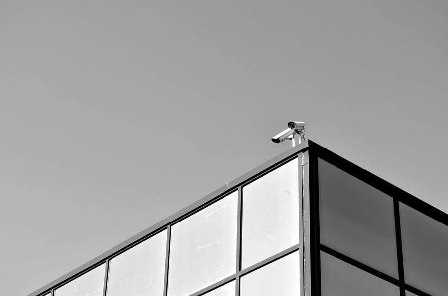 CCTV camera on the roofline of a glass-fronted building